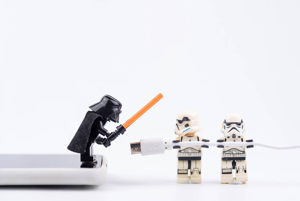 Bangkok, Thailand - 13 november 2020: Lego Star Wars helpt een USB-kabel te dragen om mobiele telefoons op te laden in Bangkok, Thailand - Foto, afbeelding