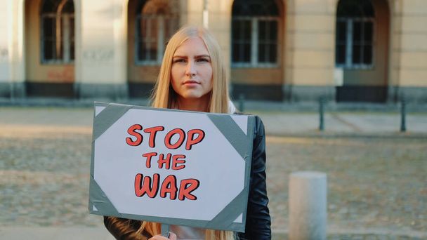 Młoda kobieta wzywa do zaprzestania wojny trzymając parowiec - Zdjęcie, obraz