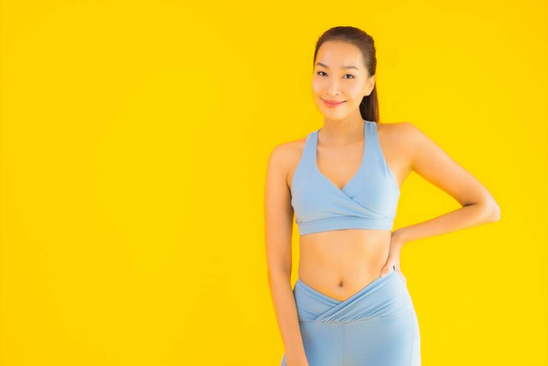 Sarı izole edilmiş arka planda spor giysili güzel Asyalı kadın portresi egzersize hazır. - Fotoğraf, Görsel