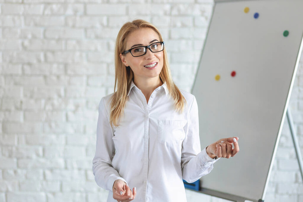 Businesswoman leads conference on whiteboard background - Valokuva, kuva