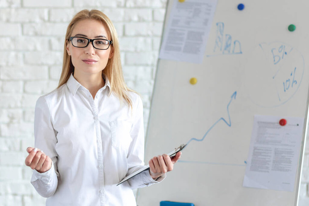 Young woman showing income growth diagram on flip chart  - Foto, Imagem