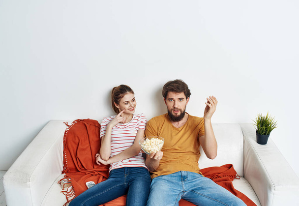 married couple on the couch popcorn watching tv indoors man woman - Photo, Image