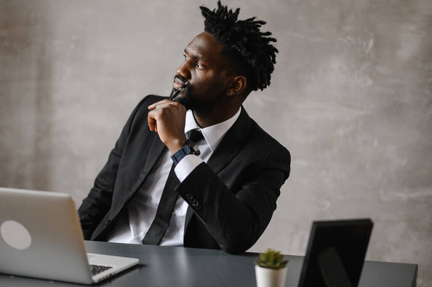 Confident young african man look at webcam conference video calling in office, happy mixed race entrepreneur talking doing online video chat job interview sit at desk - Foto, afbeelding