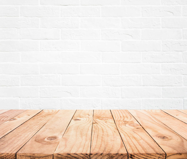Piano tavolo in legno vuoto con sfondo muro in mattoni bianchi. - Foto, immagini