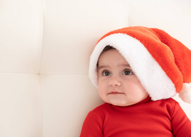 portrait baby girl 6 month in red bodysuit and Santa hat. minimalist. - Photo, Image