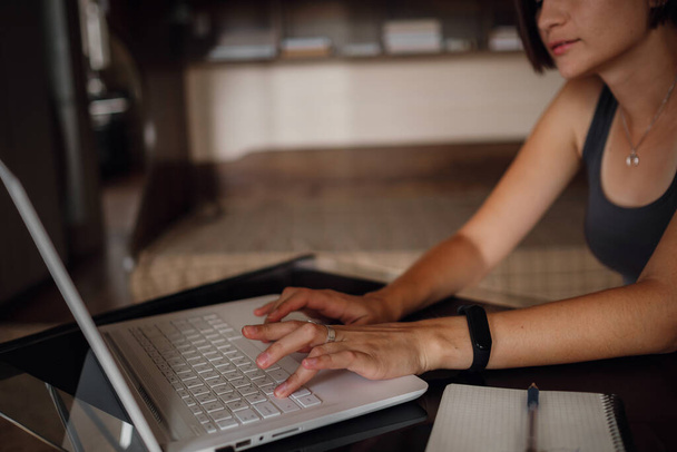 Молода азіатська студентка, яка використовує ноутбук, спілкується в Інтернеті. Затишне офісне робоче місце, віддалена робота, концепція електронного навчання. крупним планом руки
 - Фото, зображення