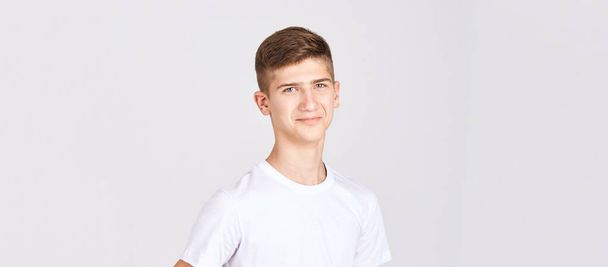 Teenager portrait. Young male person at studio. Look at camera. White T-shirt - Fotoğraf, Görsel
