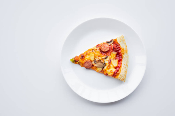 Vue du dessus un morceau de pizza sur la vaisselle blanche.Nourriture simple et concepts alimentaires - Photo, image