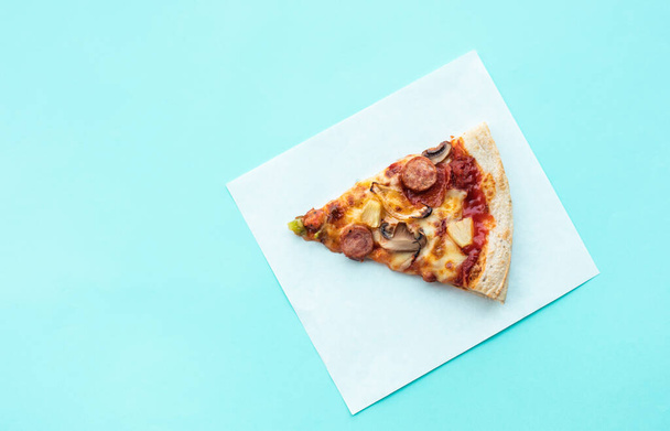 Vue du dessus un morceau de pizza sur papier coloré.Nourriture simple et concepts de manger - Photo, image
