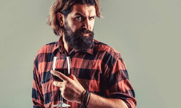 Man holding bottle with champagne, wine. Bottle, red wine glass. Beard man, bearded, sommelier, tasting. Red wine in bottle, wine glass. Sommelier man, degustation - Foto, imagen