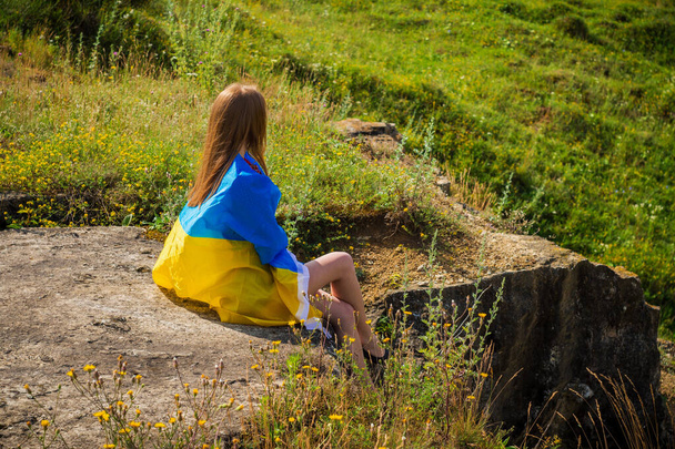 Egy lány a parkban zászlót tart a hátán Ukrajnában. - Fotó, kép