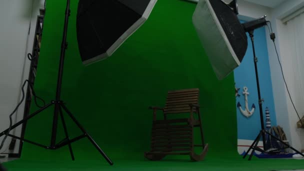 Photo or video studio with two hexagone studio lights. Green screen and rocking chair - Footage, Video