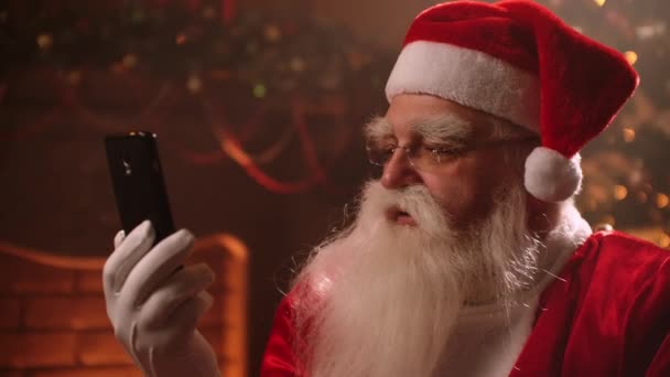 Kerstman is chatten met kinderen door video chat in smartphone van zijn huis op de Noordpool - Video