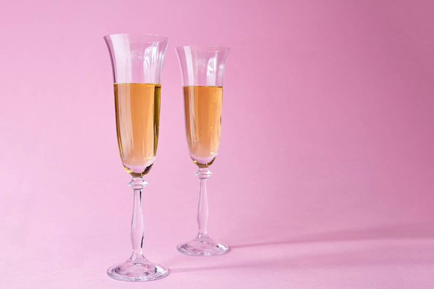 Two glasses of champagne on pink background - 写真・画像