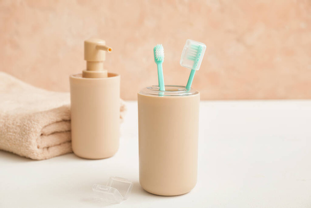 Cepillos de dientes con jabón en la mesa en el baño
 - Foto, Imagen