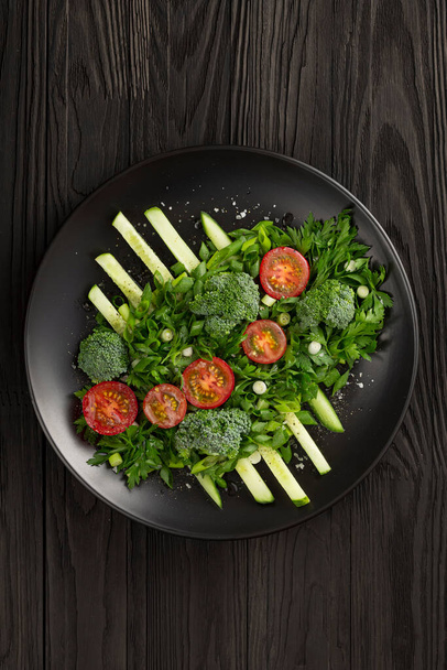 Sebze salatası ve siyah tabakta haute mutfağı. Fotoğraf gösterişsiz. - Fotoğraf, Görsel