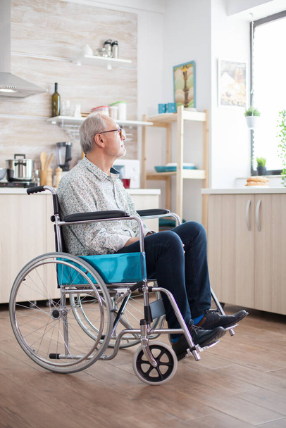 Unhappy disabled senior man sitting in wheelchair - Fotoğraf, Görsel