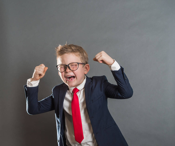 Confident child businessman raised up his hands with win position. Success winner business concept. Back to school - Фото, изображение