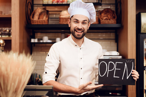 Young Happy Man with Open Sign Standing in Bakery. - Foto, immagini