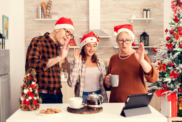 Niece and grandparent celebrating christmas saying hello during online call - Фото, зображення