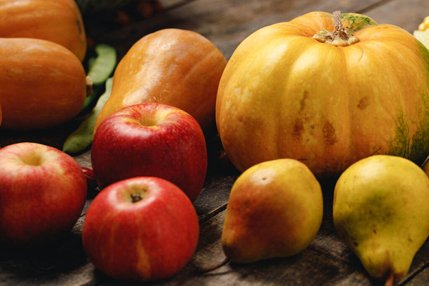Pile of red apples and pumpkins on wooden surface - Foto, Imagem