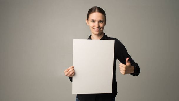woman holding a sheet of paper in her hand - Фото, зображення