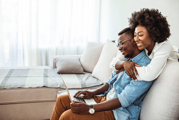 Happy African American couple using laptop, receive good news online, email, positive decision from bank, smiling wife and husband looking at screen together, mortgage or loan approve paper letter - Fotoğraf, Görsel