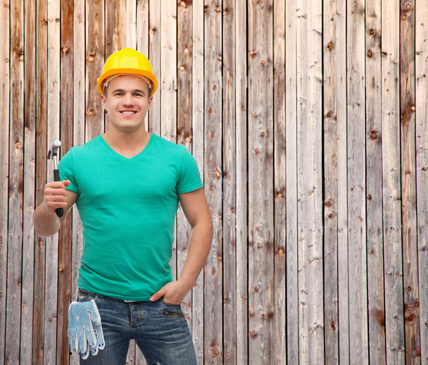 Smiling manual worker in helmet with hammer - Zdjęcie, obraz