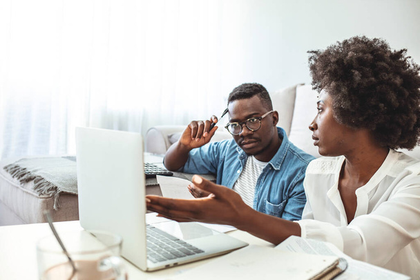 Serious worried african american couple reading documents consider mortgage loan insurance contract terms, focused black man and woman holding checking bank papers at home, domestic bills concept - Foto, Imagen