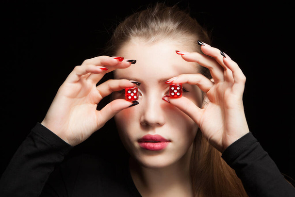 Young woman with red dice on black background - Фото, зображення