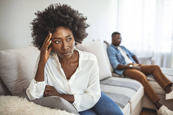 Unhappy Couple After an Argument in the Living Room at Home. Sad Pensive Young Girl Thinking of Relationships Problems Sitting on Sofa With Offended Boyfriend, Conflicts in Marriage, Upset Couple After Fight Dispute - Foto, imagen