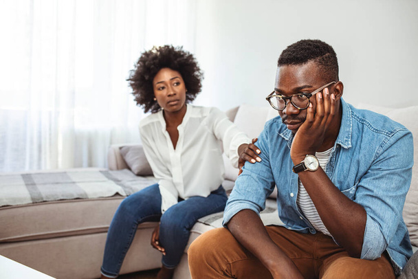 Cropped shot of an unhappy young couple after a fight at home. Unhappy young millennial married couple sitting on couch in living room after quarrel fight. Angry husband frustrated offended wife at home. - Fotoğraf, Görsel