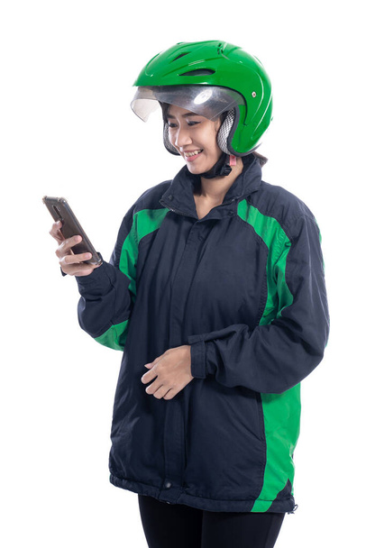 asian beautiful delivery courier with helmet holding smartphone - Zdjęcie, obraz