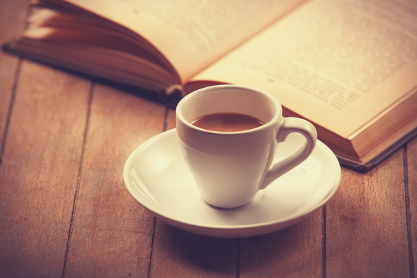 Biała filiżanka kawy i książki vintage.  - Zdjęcie, obraz