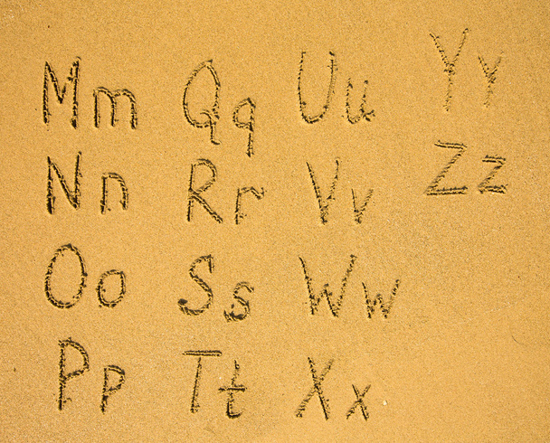砂のビーチに書かれたアルファベット - 写真・画像