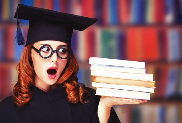 Étudiante diplômée en robe académique avec des livres
 - Photo, image