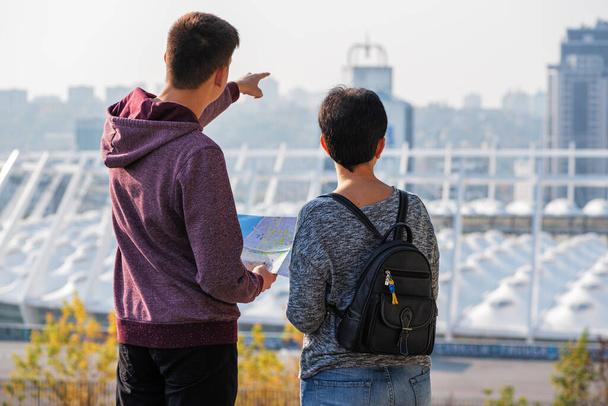 Szczęśliwa matka i syn stojący na tarasie widokowym i patrzący na miasto cieszący się spędzaniem czasu razem na wakacjach. Widok z tyłu - Zdjęcie, obraz