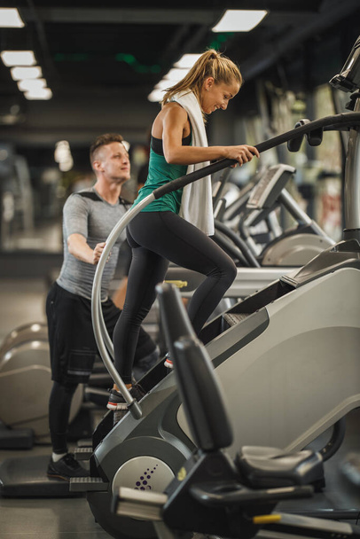 Shot of an attractive young woman exercising on the stepmill machines   at the gym. - Фото, изображение