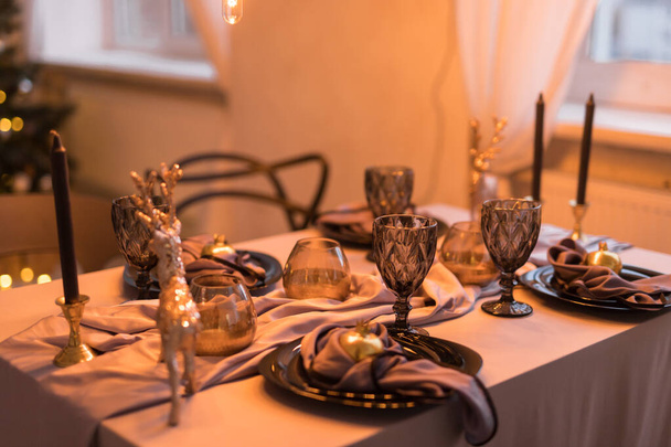 Lähikuva juhlapöydän, jossa on tyhjät viinilasit ja musta lautanen. Joulun ja uudenvuoden käsite - Valokuva, kuva