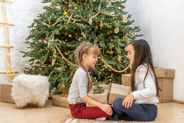Two little girls with a christmas present - Фото, зображення
