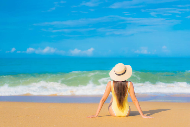 Retrato hermosa joven asiática mujer relajarse sonrisa ocio alrededor al aire libre tropical mar playa océano en viaje vacaciones - Foto, imagen