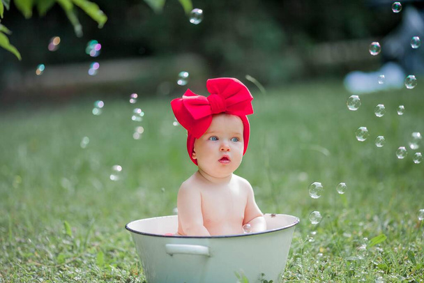 pouco bonito menina banhos em uma bacia ao ar livre - Foto, Imagem