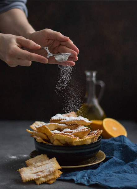 Cooking  "sfrappole" or "chiacchiere". Italian traditional sweet crisp pastry deep-fried and sprinkled with powdered sugar. Commonly eaten during Carnival and on Fat Thursday. - Fotó, kép
