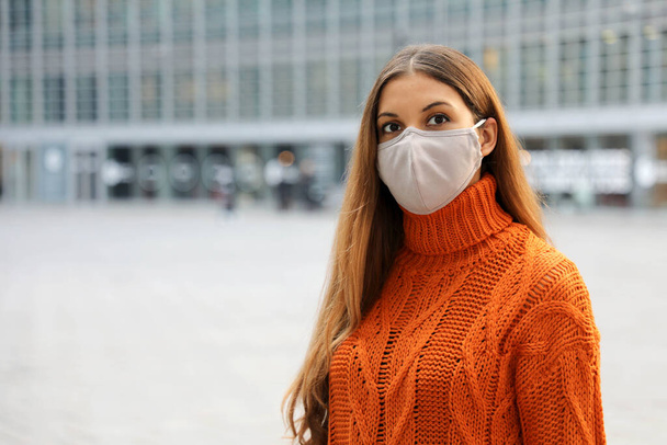 Πορτρέτο μιας νεαρής επιχειρηματία φορώντας προστατευτική μάσκα στέκεται στο δρόμο κοιτάζοντας μπροστά της ανησυχούν. Αντιγραφή χώρου. - Φωτογραφία, εικόνα