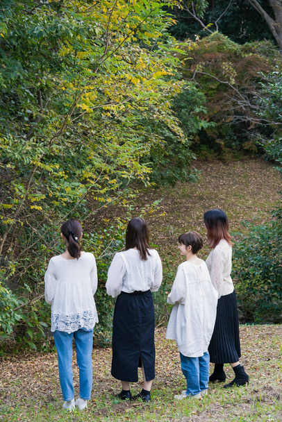 Beyaz gömlek giyen ve parkta sohbet eden 4 Japon genç kadın. - Fotoğraf, Görsel