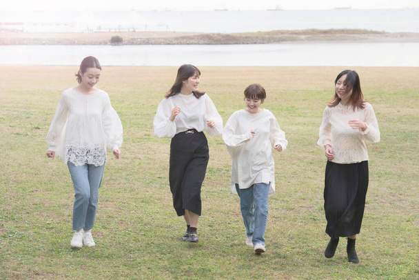 Cuatro jóvenes japonesas corriendo lentamente en el estado de ánimo de relax - Foto, Imagen