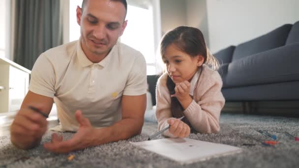 Father and daughter communicate, having fun and painting together. Concept of a happy family and quality leisure time - Footage, Video