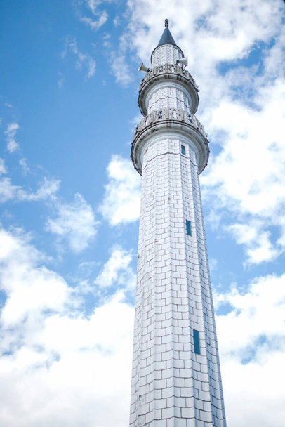 A vertical low angle shot of a minaret  on a cloudy sky background - Фото, зображення