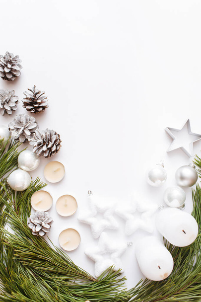 Navidad, invierno, composición de año nuevo. Ramas de abeto, cono de pino, velas sobre fondo blanco. Plano, vista superior, espacio para copiar - Foto, imagen