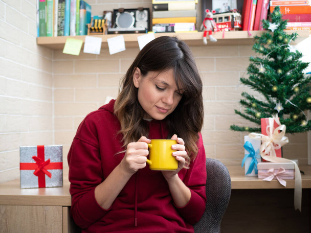 Happy attractive woman enjoy her coffee in a mug waiting a Christmas - Photo, Image